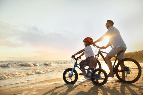 Father and Son Riding Bikes on the Beach