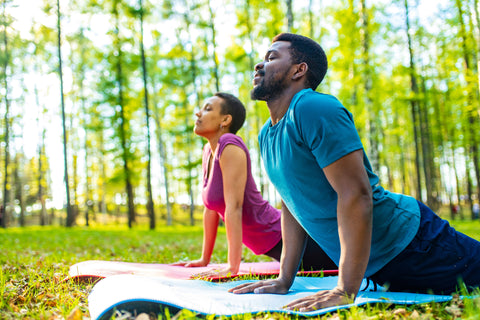 Happy Active Couple with Balanced Saliva Hormone Levels Doing Yoga Outside