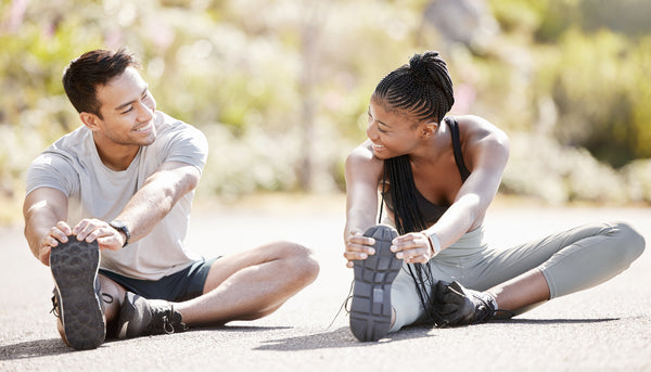 Sport, fitness and exercise with a sports man and woman training and stretching during an outdoor workout