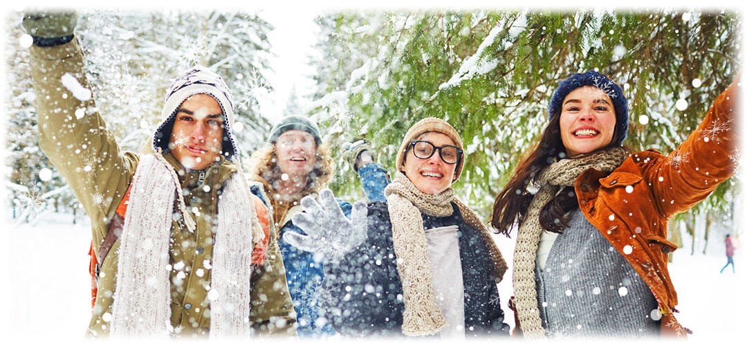 An image capturing a festive outdoor scene of a group of friends during Christmas, showcasing trees covered in snow. The image evokes the spirit of Christmas celebrations held outdoors in 2023