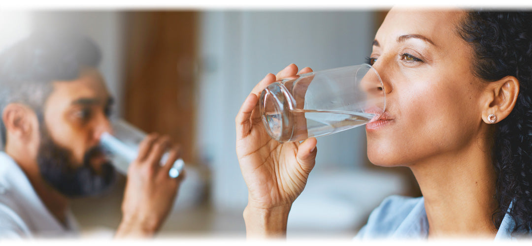 Image of a person drinking water from a glass, promoting hydration and health.