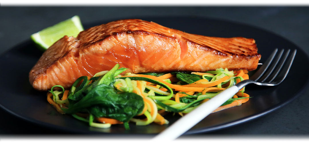 A plate with grilled salmon fillet, steamed vegetables, and rice, representing a healthy and balanced meal.