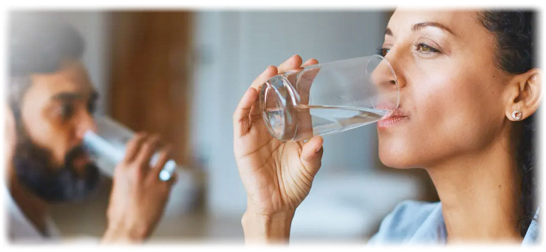 Man and woman drinking water, promoting hydration, aligned with Lily & Loaf's wellness