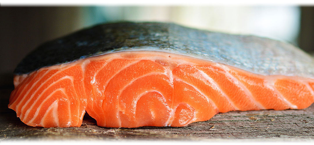 An image featuring fresh salmon fillets and lemon slices. The image suggests the topic of salmon and its health benefits