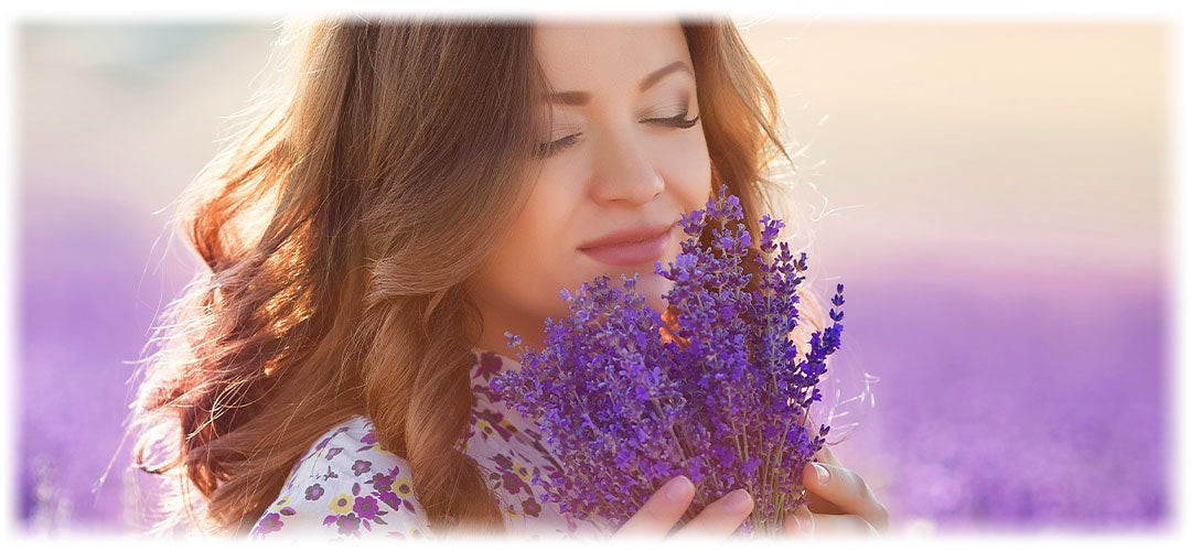 Woman inhales the Natural fragrance of lavender, Lily & Loaf's essence for calm and relaxation.