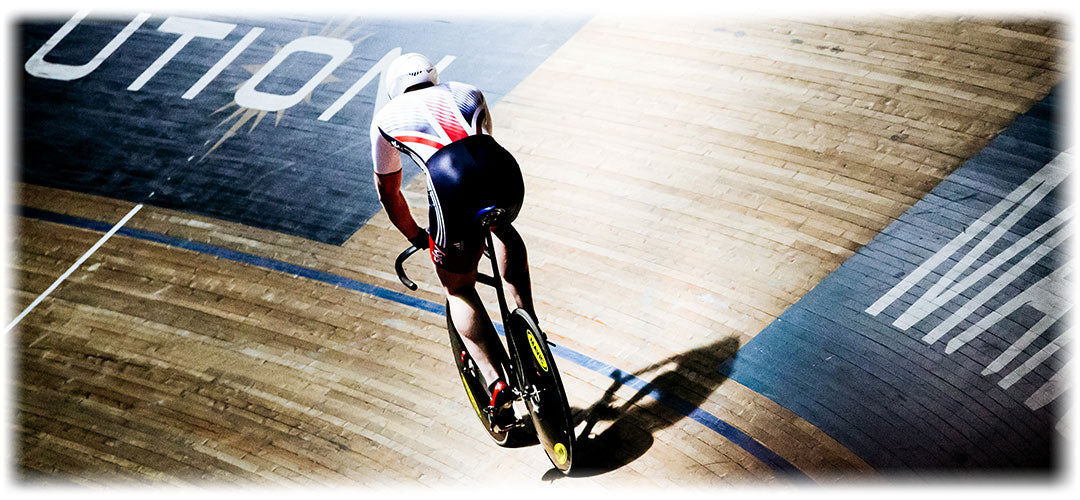 Cyclist in motion on track, representing the active lifestyle supported by Lily & Loaf's sports nutrition.