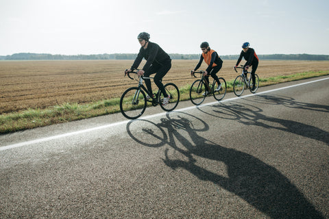 A man riding a bicycle on a sunny day with a city skyline in the background