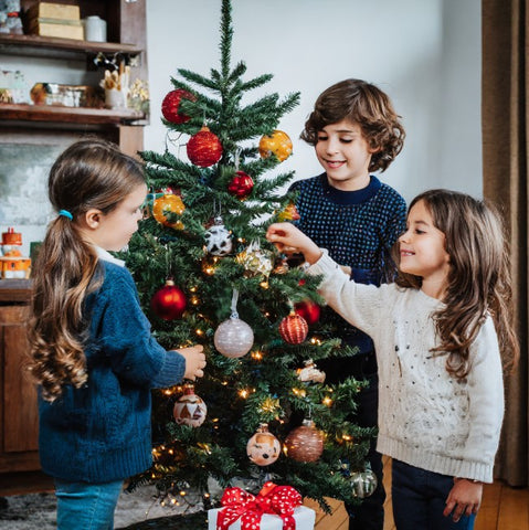 children decorating a christmas tree