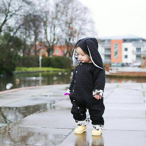 cute baby girl wearing bayridgecaskandkeg monochrome bunny pramsuit with splatter effect lining and yellow boots