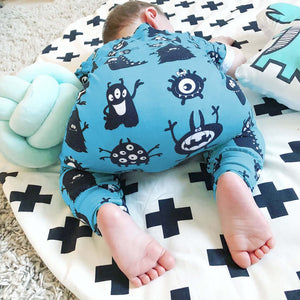 Little boy wearing the blue monsters short sleeved popper romper by bayridgecaskandkeg