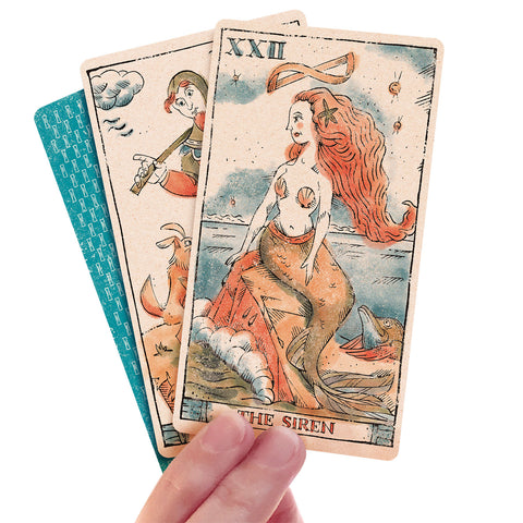 Tarot Of Musterberg Woman's hand holding 3 cards the Fool the Siren and back of card showing