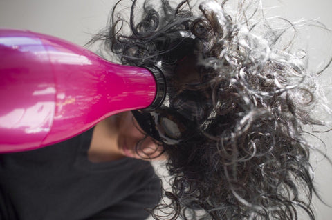 Woman blow drying hair 