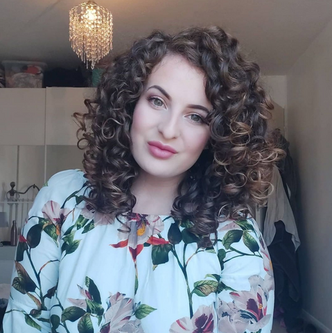 White woman with brown hair, big curls