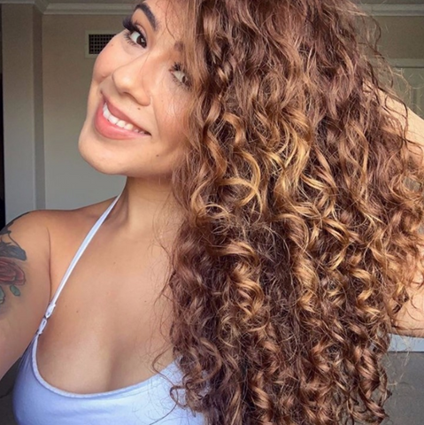 Latina woman with light brown curly hair 