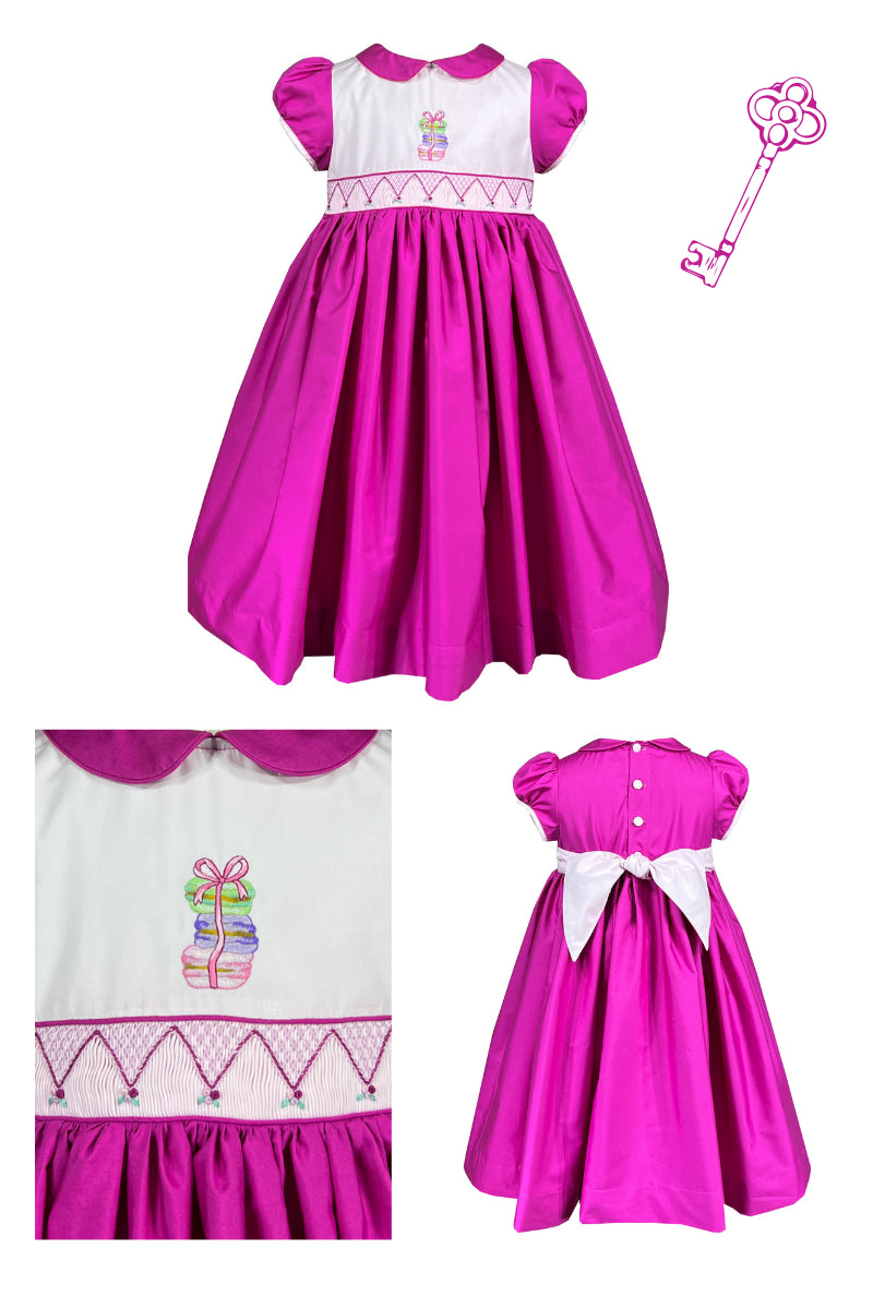 Bright pink girls smocked dress with embroidered macaron detail