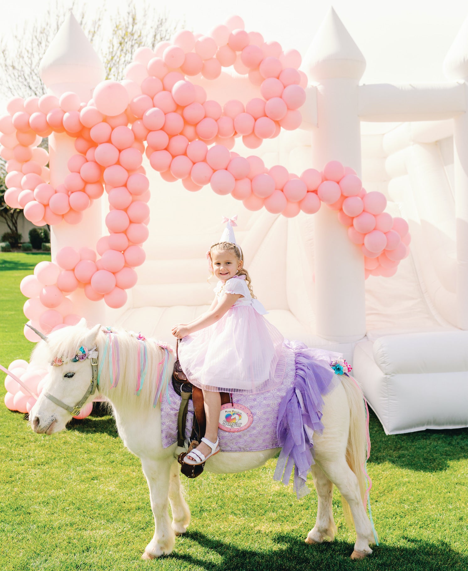Unicorn and bow bounce house Arizona kids party Charlotte sy Dimby pink bow pearl party dress and inspiration for children little princess