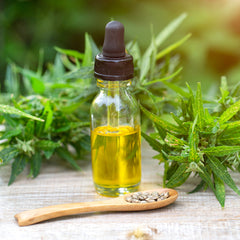 A bottle containing Australian Hemp seed oil beside Hemp seeds on a spoon