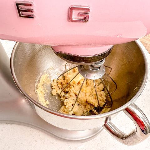 pink mixing machine mixing together sugar and butter