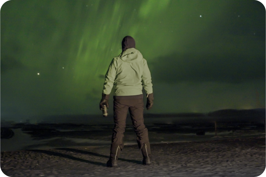 Man standing in front of Northern lights in Iceland