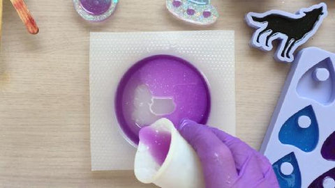 pouring purple resin into coaster mold