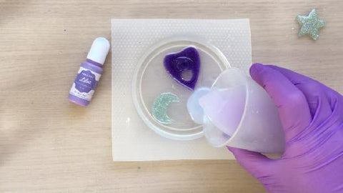 pouring purple resin into coaster mold