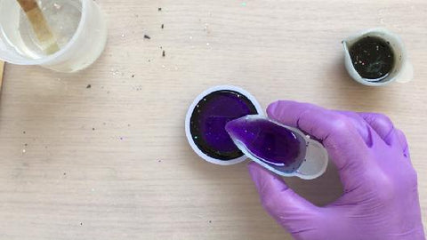 pouring purple resin mix into silicone mold