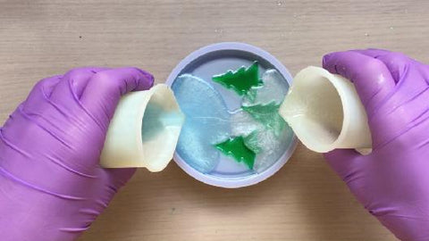 pouring white and blue resin mix into coaster mold