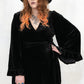 Model wearing Rock City Velvet Wrap Dress - Black Heavy, luxe velvet fabric, true wrap style, bell sleeves with frill detailing, deep V-neck