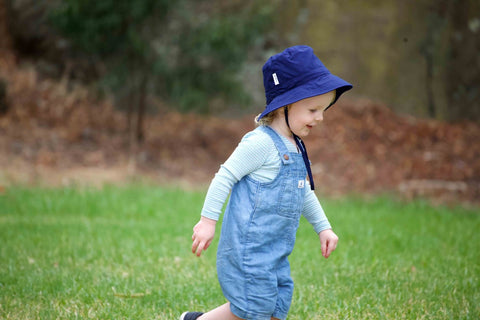 Boy running at the park with a Jordbarn Indigo bucket hat