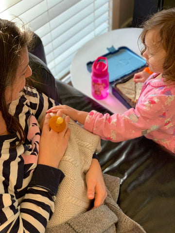 Breastfeeding mum whilst toddler is entertained with a bento lunch box