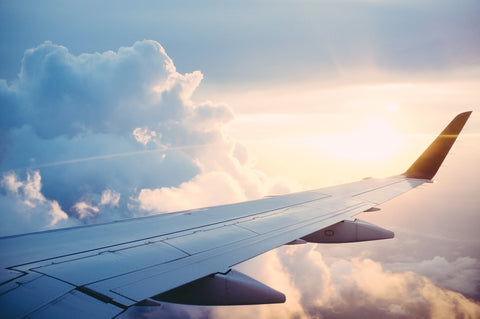 Travelling with kids, looking out the window of a plane and into the sunset