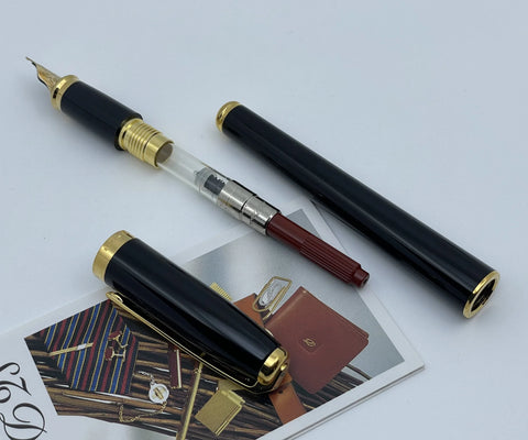 S.T. Dupont olympio fountain pen with ink converter sticking out.