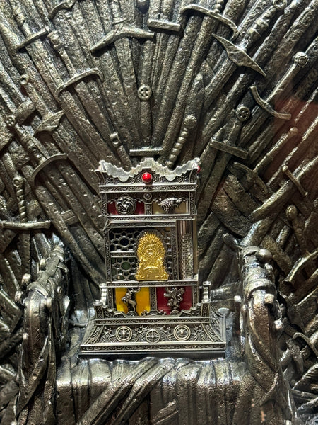 S.T. Dupont Haute Creation Game of Thrones lighter sitting atop Iron Throne Replica. Close up of the intricate engravings on the face of the lighter