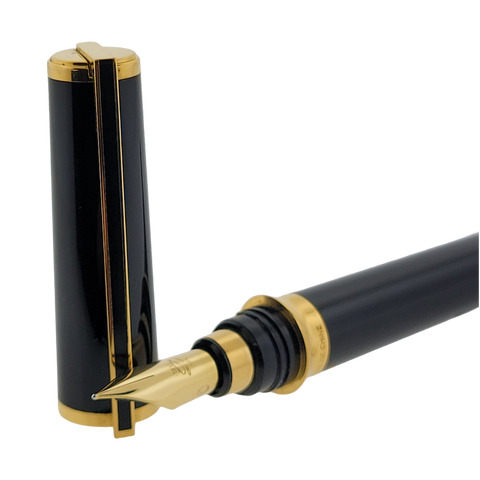 S.T. Dupont Montparnasse fountain pen in black lacquer with gold accents. The cap is open standing next to the nib of the pen.