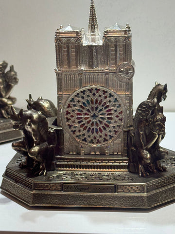 Intricate S.T. Dupont Notre Dame lighter featuring detailed gothic architecture and statuary, with Notre-Dame de Paris inscription on the base.
