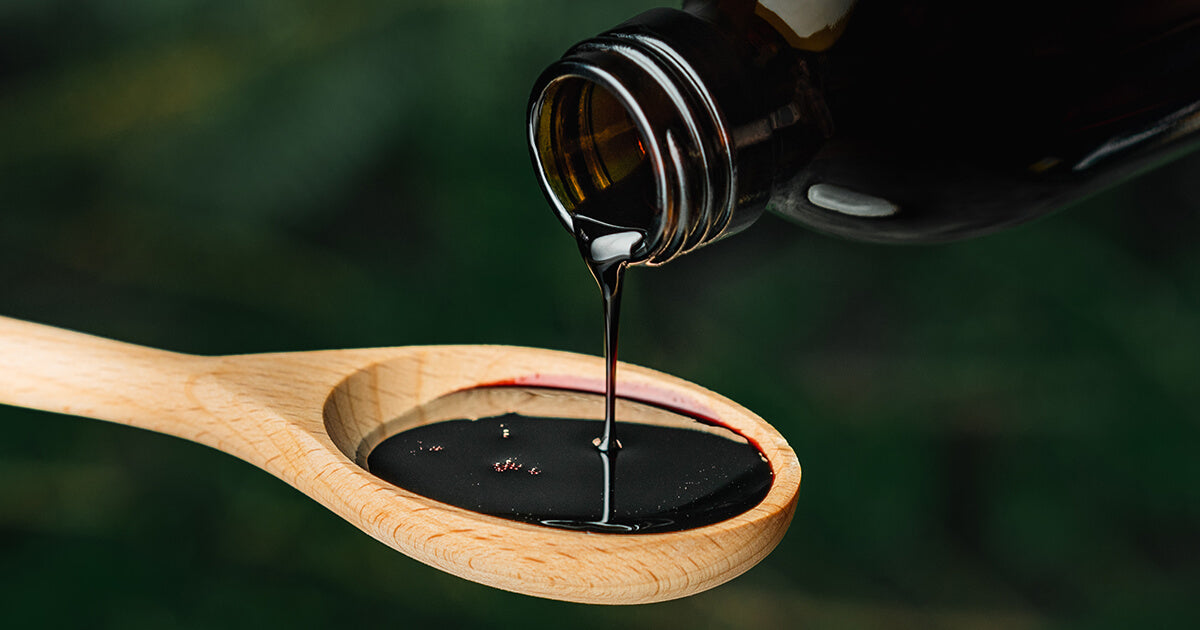 Black Elderberry Syrup poured on spoon