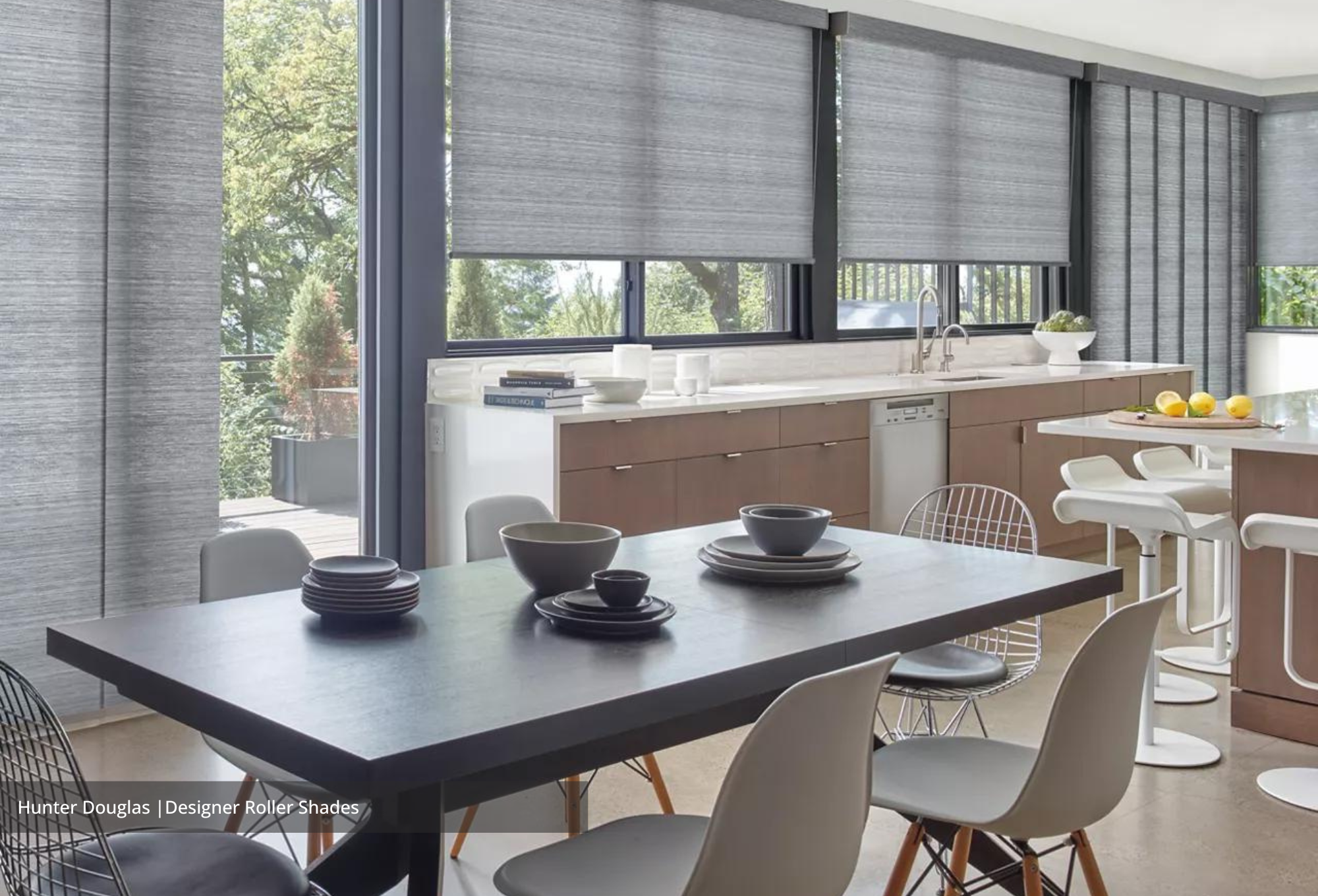 A room with modern decor and large windows covered with roller shades