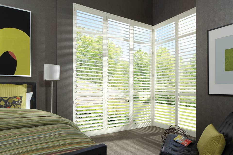 Green bedroom with Hunter Douglas NewStyle® Hybrid Shutters