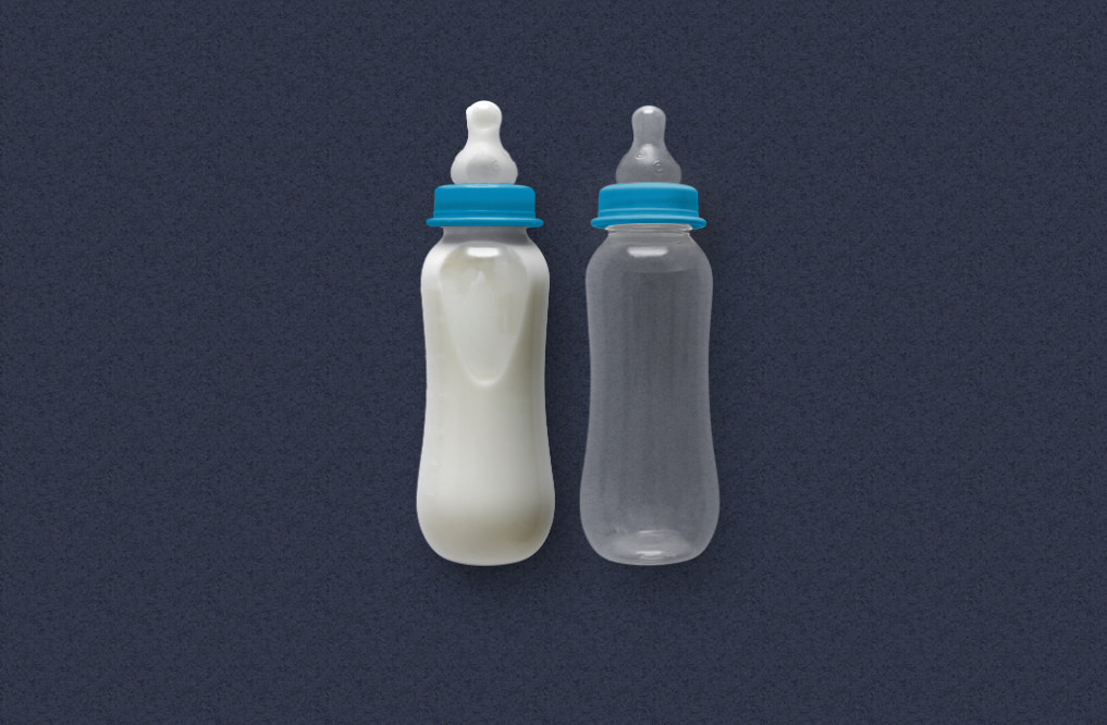 There are two milk bottles. One is filled with milk and one is empty.