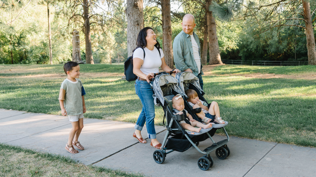 family with baby in a stroller walking in the park