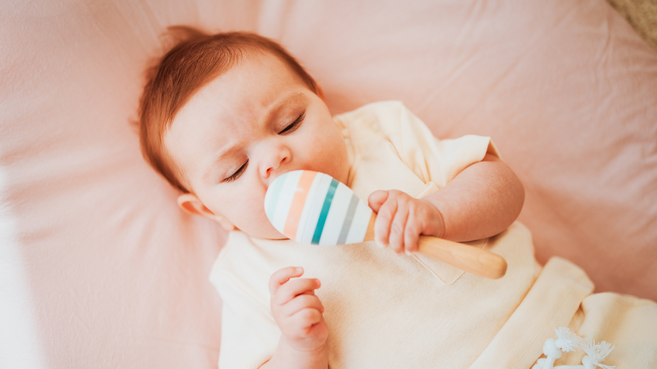 baby holding a toy lying down