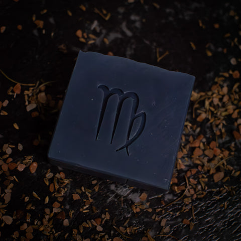 virgo soap symbol on black surface with herbs