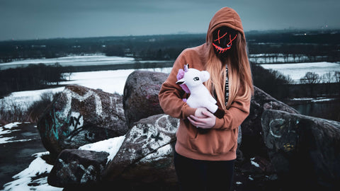 woman in halloween mask holding unicorn