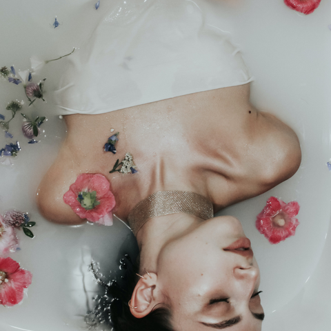 woman in milk bath with flowers