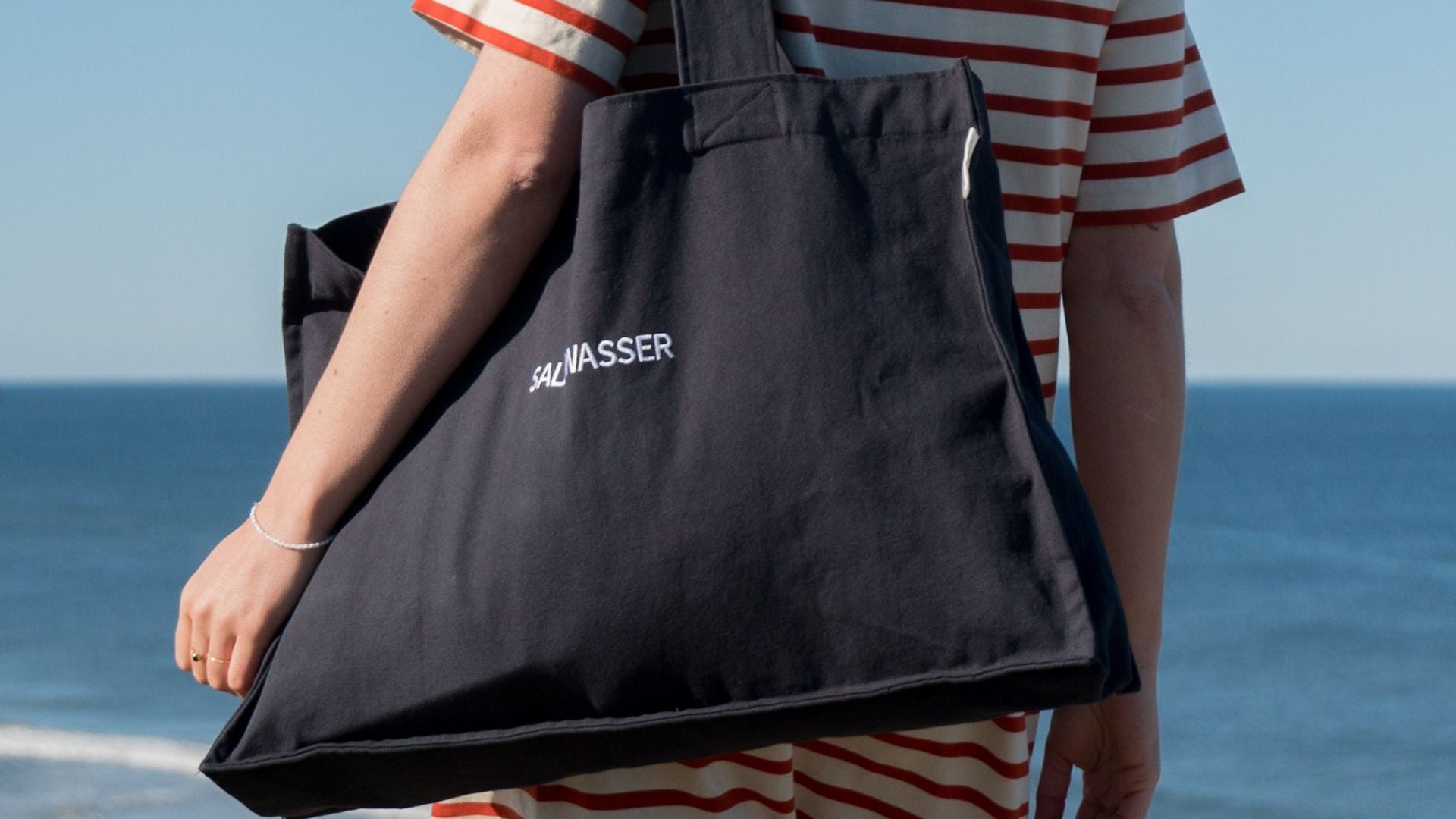 Frau mit Strandtasche auf dem Weg zum Strand