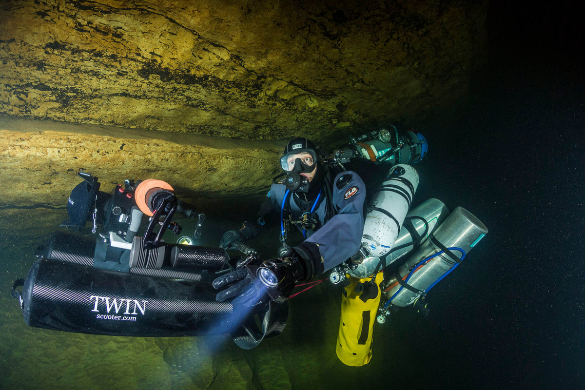 Uli Kunz taucht mit Ausrüstung durch eine Unterwasserhöhle 