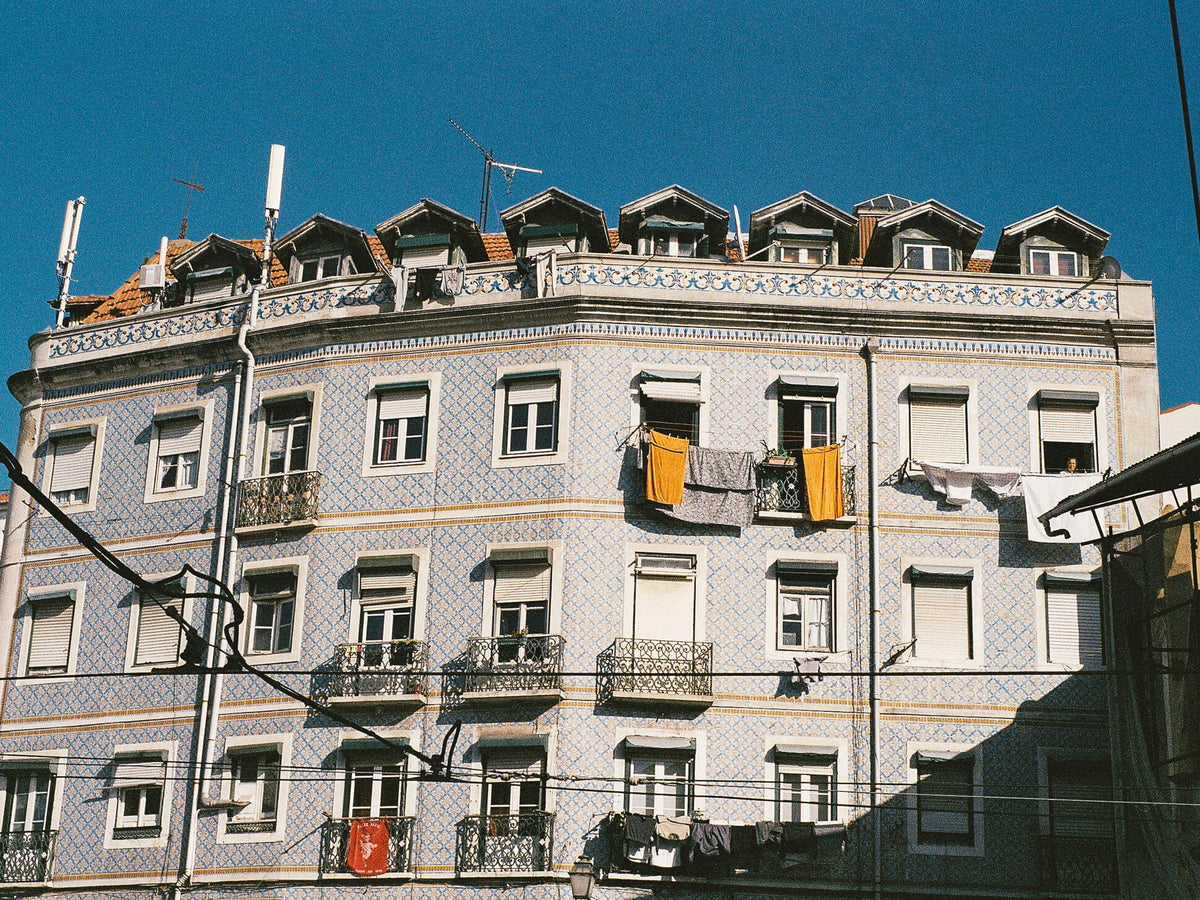 Hausfassade mit Kachelkunst und Wäscheleinen in Lissabon