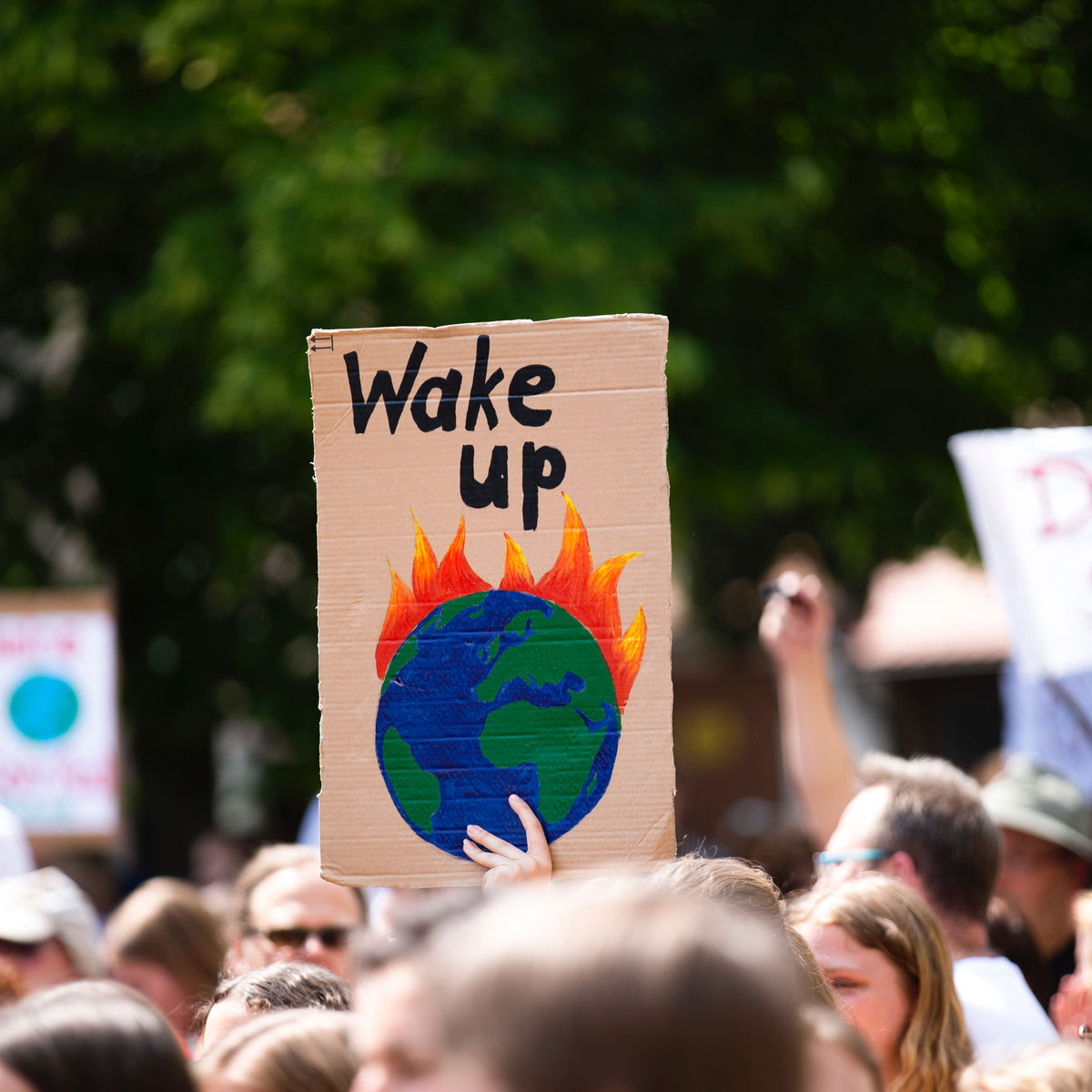 Protestanten mit Schild gegen Folgen des Klimawandels mit Erwärmung und Versauerung der Meere