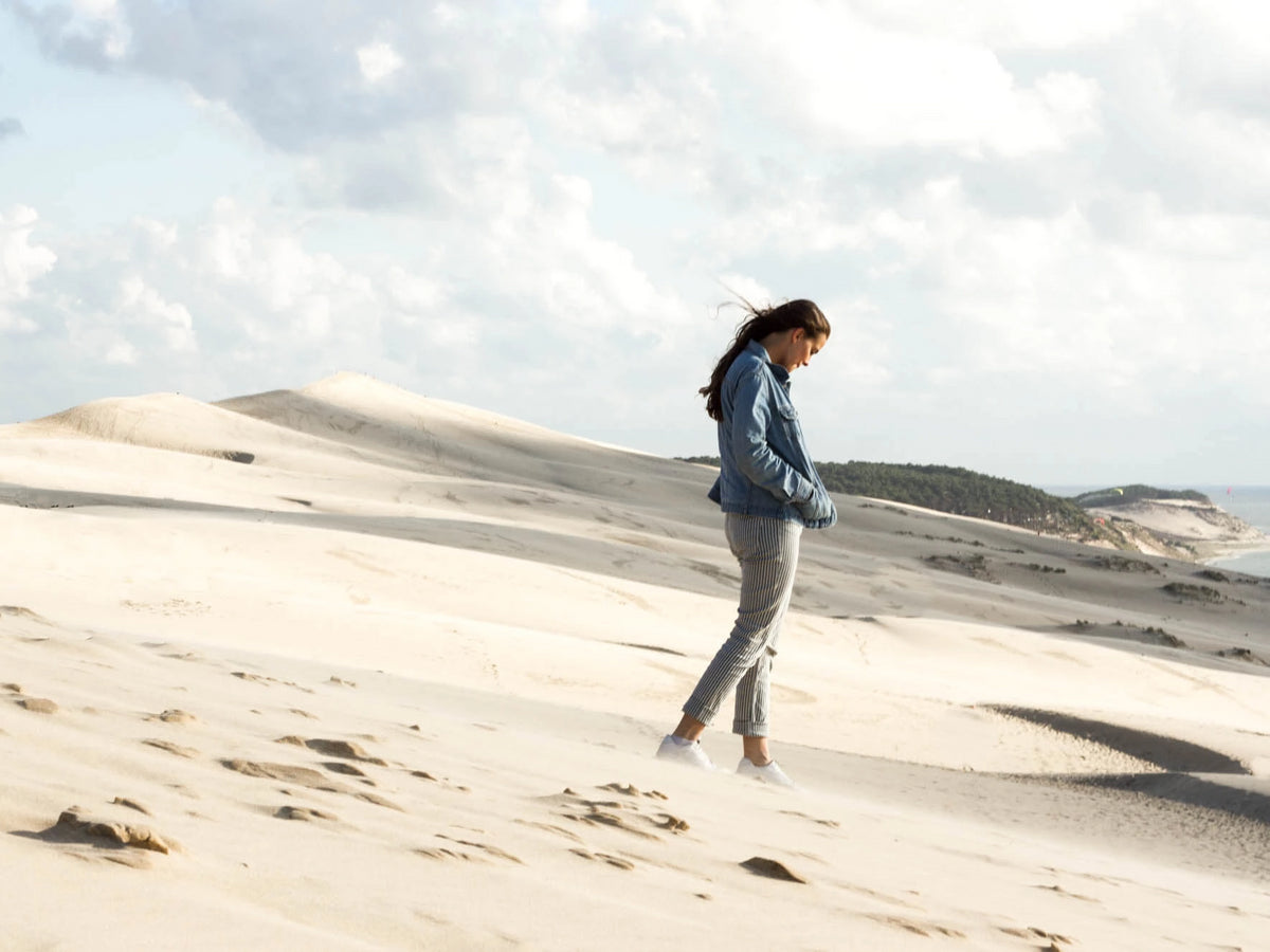 Frau alleine im Wind auf der Düne Dune du Pilat in Frankreich