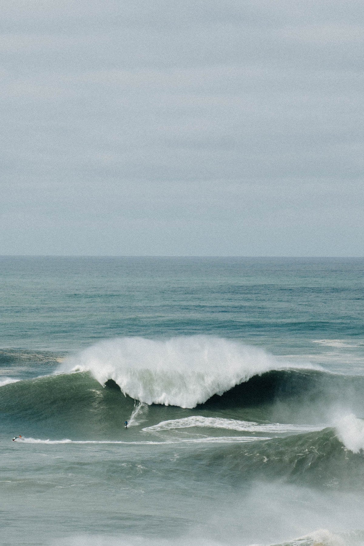 Surfer auf Riesenwelle in Nazaré